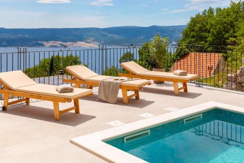 a patio with two lounge chairs and a swimming pool at Holiday Home La Montagna - Private Heated Pool in Lokva Rogoznica