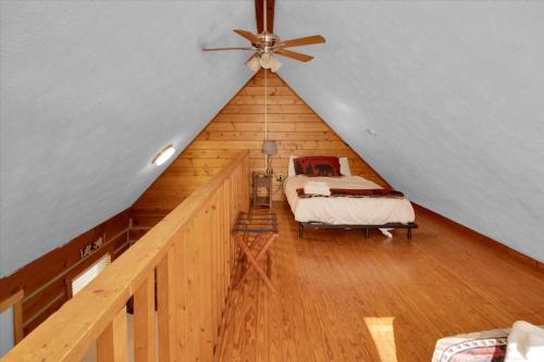a room with a bed and a ceiling fan at Charming Cabin with Parking in Pigeon Forge