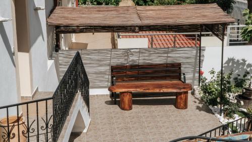a wooden bench sitting under a gazebo at Εunia Guest house in Rotásion