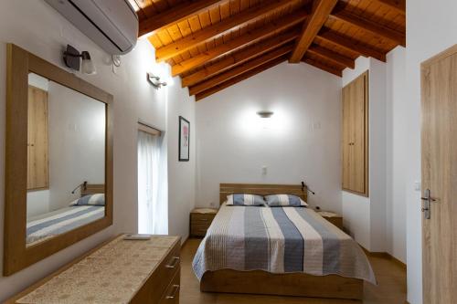Un dormitorio con una cama y un espejo grande. en Ouranias house, en Kokkari