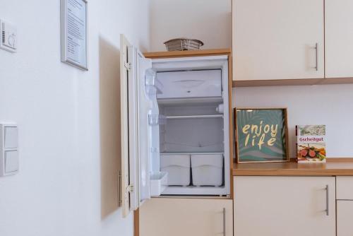 an empty refrigerator with its door open in a kitchen at Ferienwohnung Naturnah Ebermannstadt in Ebermannstadt