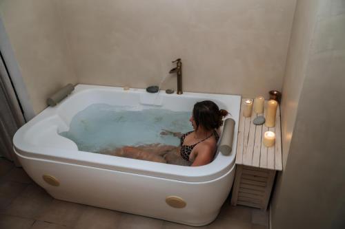 a woman is sitting in a bath tub at Εunia Guest house in Rotásion