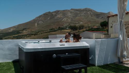 two people in a bath tub with a mountain in the background at Εunia Guest house in Rotásion