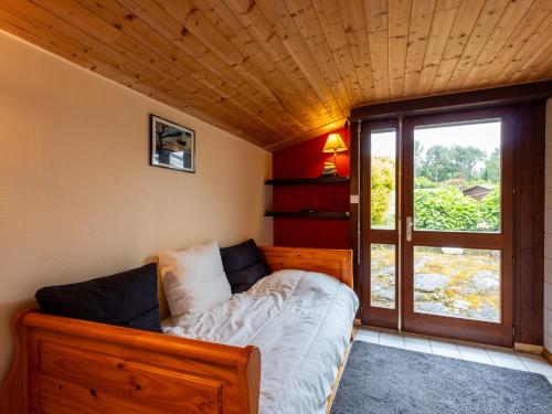 ein Schlafzimmer mit einem Bett in einem Zimmer mit Fenster in der Unterkunft Maison Kervégan à 200m de la mer in Pleumeur-Bodou