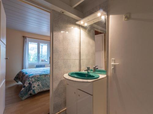 ein Badezimmer mit Waschbecken und ein Bett in einem Zimmer in der Unterkunft Maison Kervégan à 200m de la mer in Pleumeur-Bodou