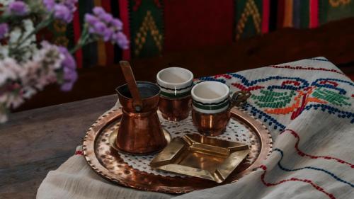 a tray with three cups and a plate with a candle at Εunia Guest house in Rotásion