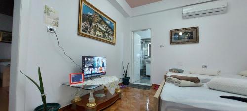 a living room with a bed and a desk with a computer at Guest House Flowers in Berat