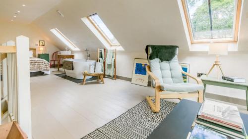 a attic room with a chair and a desk at Bwthyn Ysgubor in Conwy