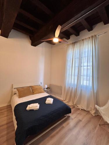 une chambre avec un lit et une grande fenêtre dans l'établissement Appartement - Albi Cathédrale, à Albi