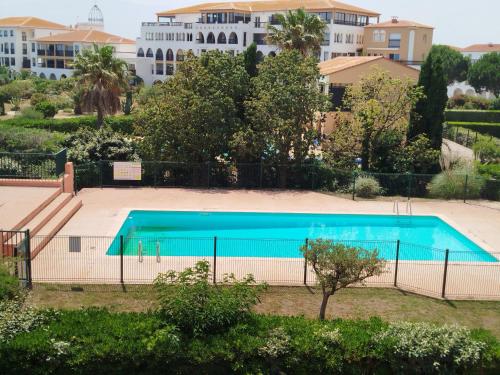 une piscine vide en face d'un bâtiment dans l'établissement Front de mer pour ce t2 dans résidence avec piscine collective -4TRO94, à Saint Cyprien Plage