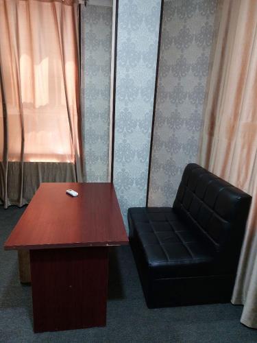 a table and a black chair and a table and a bench at Zamona in Muruntau