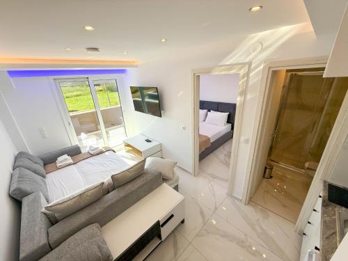 a living room with a couch and a bed at IFESTOS SUITES by SDR in Paralia Katerinis