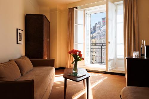 a living room with a couch and a large window at Hotel Rochechouart - Orso Hotels in Paris
