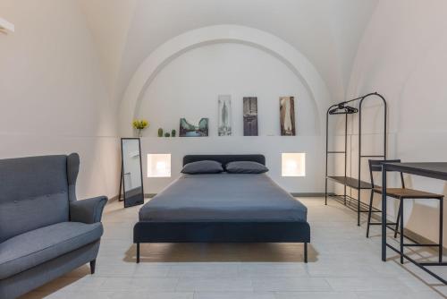 ein Schlafzimmer mit einem Bett, einer Couch und einem Stuhl in der Unterkunft House Mandarino in Bari