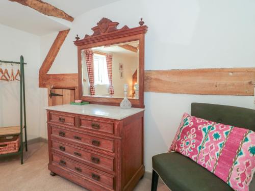 a bedroom with a dresser and a mirror at Old Farm Cottage in Warminster