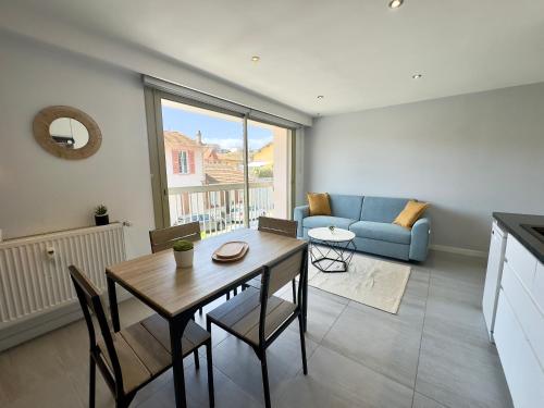 un salon avec une table et un canapé bleu dans l'établissement La Rose d'Or - SCLS Locations, au Cannet