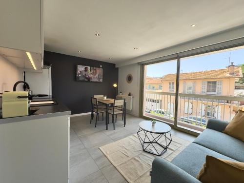 une cuisine et un salon avec un canapé et une table dans l'établissement La Rose d'Or - SCLS Locations, au Cannet