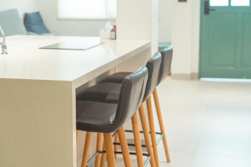 a row of stools at a kitchen counter at 小樹林 Little Mori 包棟民宿 in Tainan