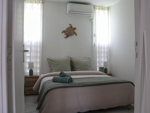 a bedroom with a bed with a turtle clock on the wall at Éden Escale Premium in Les Abymes