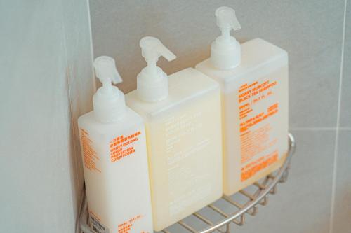 three bottles ofodorizers sitting on a shelf in a bathroom at 小樹林 Little Mori 包棟民宿 in Tainan