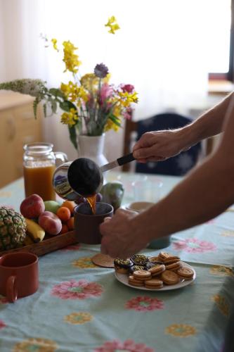 a person cooking food on a table with a plate of food at Kuća Ugor in Lun