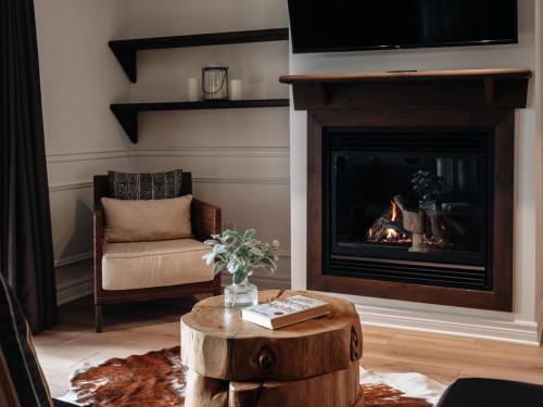 a living room with a fireplace and a chair at Luxurious ski-in ski-out condo in Saint-Sauveur in Saint-Sauveur-des-Monts