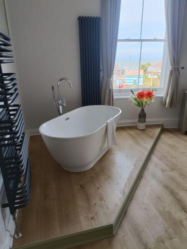 a white bath tub in a bathroom with a window at The Beach Hotel in Minehead