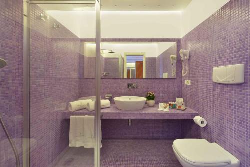 a purple bathroom with a sink and a toilet at Grand Hotel President in Sorrento