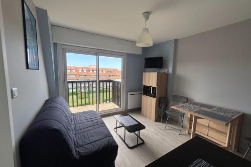 un salon avec un canapé et une table dans l'établissement Apartment 500 m from the beach Villers-sur-Mer, à Villers-sur-Mer