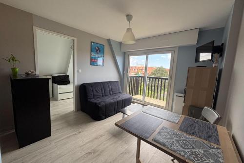un salon avec un canapé et une table dans l'établissement Apartment 500 m from the beach Villers-sur-Mer, à Villers-sur-Mer