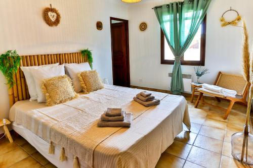 une chambre avec un grand lit avec des serviettes dessus dans l'établissement La Maison du Bonheur !, à Graveson