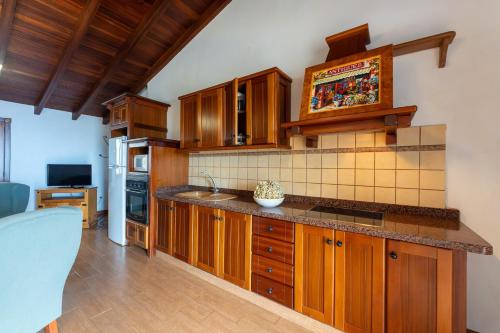 a kitchen with wooden cabinets and a counter top at Casas Rurales La Tanquera y Las Rosas in Los Realejos