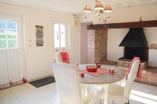 une salle à manger avec une table et une cheminée dans l'établissement Ferme du lin : Angelin, à Gueschart