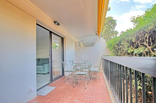 un patio avec une table et des chaises sur un balcon dans l'établissement Appartement proche Port et plages, à Antibes