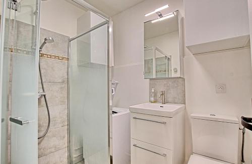 une salle de bain blanche avec une douche et un lavabo dans l'établissement Appartement proche Port et plages, à Antibes