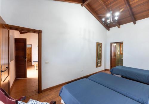 a living room with a blue bed and a mirror at Casas Rurales La Tanquera y Las Rosas in Los Realejos