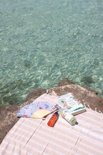 a toothbrush and a book on a table next to the water at Kuća Ugor in Lun