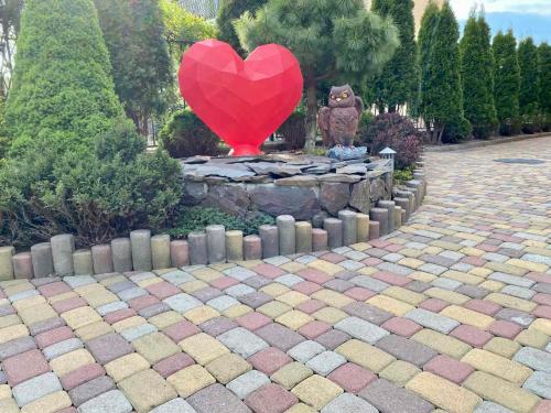 a heart statue in a garden with a red heart balloon at Dayarta in Skhidnitsa