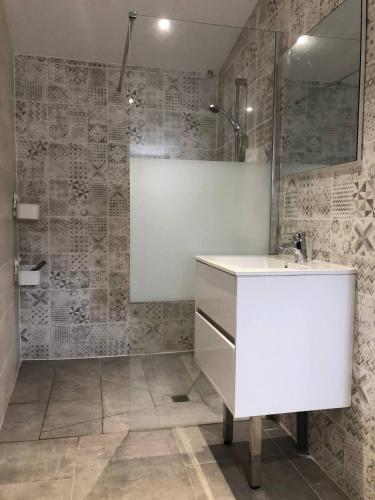 une salle de bain avec un lavabo blanc et un miroir dans l'établissement Villa Sandra - Le Verdon, Medoc, au Le Verdon-sur-Mer
