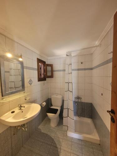 a bathroom with a sink and a toilet and a tub at Aegean soul apartment in Halki