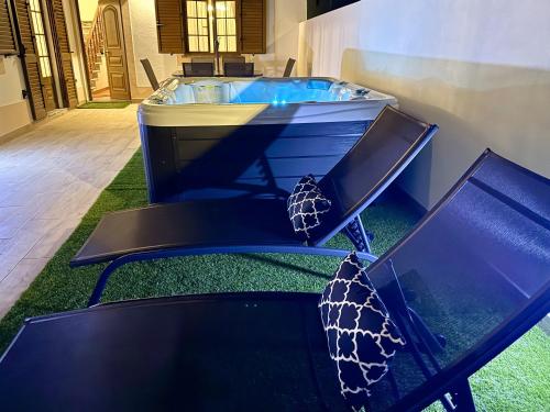 a jacuzzi tub with two chairs and a table at GOLDEN VILLA by Stay in Alentejo in Vila Nova de Milfontes