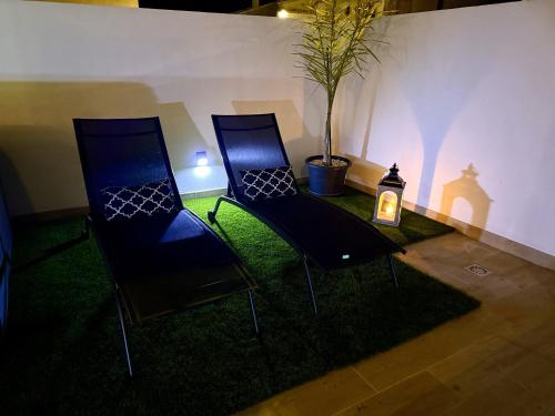 two chairs sitting next to a table with a candle at GOLDEN VILLA by Stay in Alentejo in Vila Nova de Milfontes