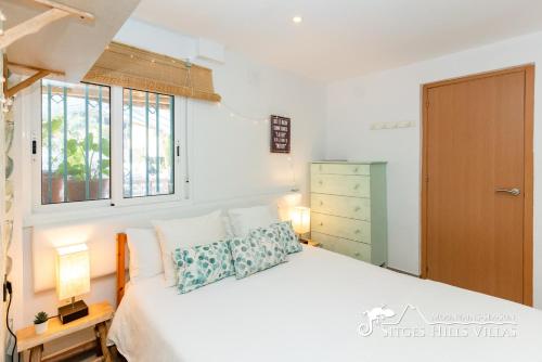 a bedroom with a white bed and a window at Beautiful Villa Encanto with private pool in Olivella