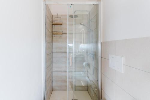 a shower with a glass door in a bathroom at Suite - Incanto su Specchia by Just Houses in Specchia