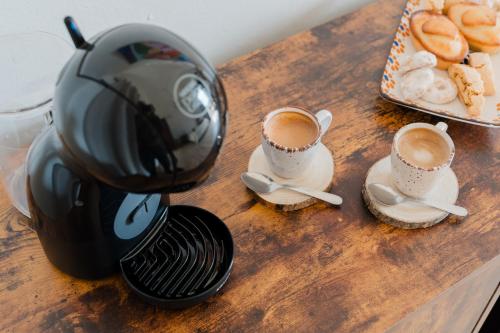 a coffee maker on a table with two cups of coffee at Suite - Incanto su Specchia by Just Houses in Specchia