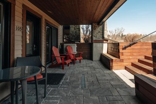 a patio with chairs and a table on a house at Chic condo at the foot of the slopes of Saint-Sauveur in Saint-Sauveur-des-Monts