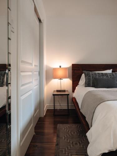 a bedroom with a bed and a table with a lamp at Chic condo at the foot of the slopes of Saint-Sauveur in Saint-Sauveur-des-Monts