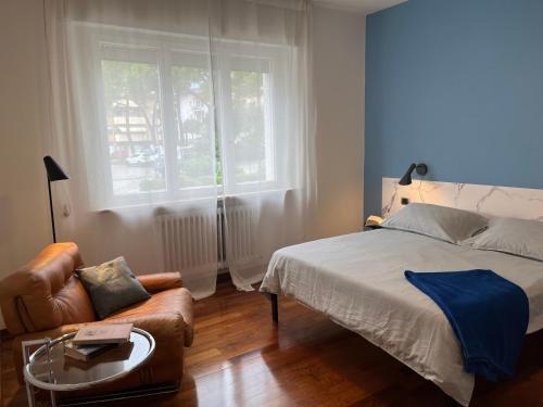 リーヴァ・デル・ガルダにあるDueOlivi - Appartamento Blueのベッドとソファと窓のある寝室