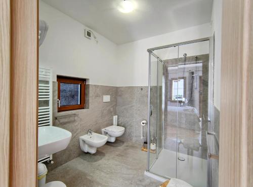 a bathroom with two toilets and a sink and a shower at Hotel Da Marco in Vigo di Cadore