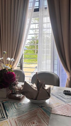 a table with a bowl of flowers on top of it at The Fath Homestay Pasir Mas Tanah Merah Rantau Panjang in Pasir Mas